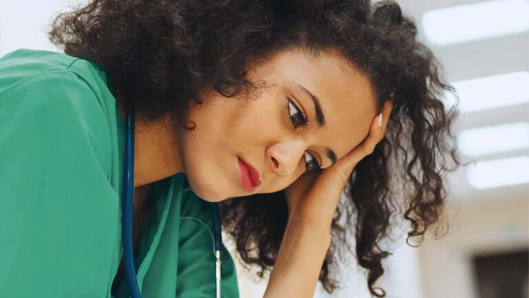 Veterinaria com expressão de cansaço e estresse na rotina clínica, representando burnout na medicina veterinária